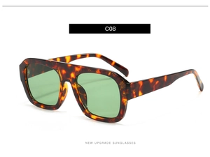 Close-up of square flat-top sunglasses in tortoiseshell frame with green lenses