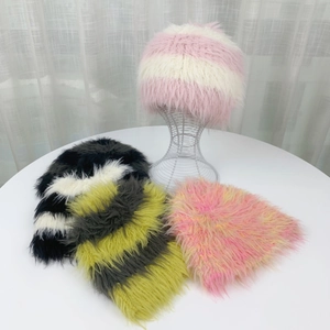 Detalle de gorros de piel sintética con rayas de colores en rosa, negro y verde sobre mesa