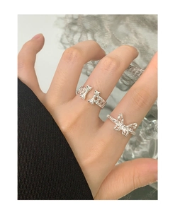 Detail view of S925 sterling silver hollow bow and butterfly rings on a model hand