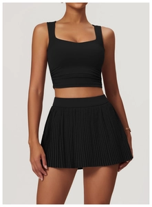 Detail of black sports top with square neck and pleated skirt for fitness and yoga