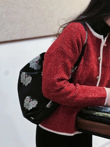 Detail of vintage style jacquard shoulder bag with intricate white butterfly embroidery