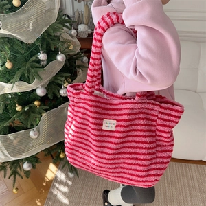 Close-up of pink and red striped plush tote bag with sozakka beauté label detail