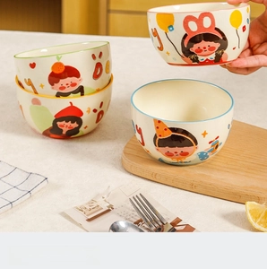 Détail de quatre bols en céramique avec illustrations de filles et bords colorés