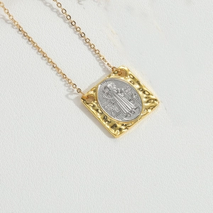 Detailed close-up of retro square pendant with silver relief on gold hammered frame
