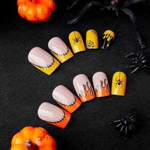 Halloween press-on nails with orange spider webs and black flame designs on matte background