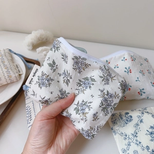 Detail der floralen Mini-Baumwolltasche mit weißem Reißverschluss und Webetikett