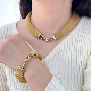 Close-up of 18K gold-plated mesh necklace and bracelet set with diamond accents