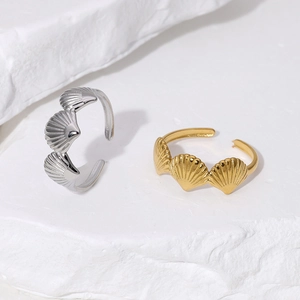 Minimalist stainless steel shell rings in gold and silver finish on natural rock