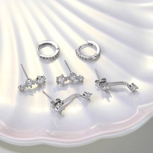 Detail of silver zirconia earring set on a pearl luster shell tray background