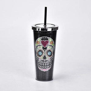 Close-up of sparkling rhinestone skull and heart design on a black straw cup