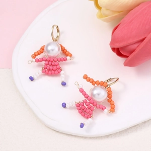 Detailed view of handmade beaded girl earrings with pearls and colorful beads on tray