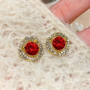 Detalle macro de alta calidad de pendientes de botón con strass rojo y cristales blancos brillantes