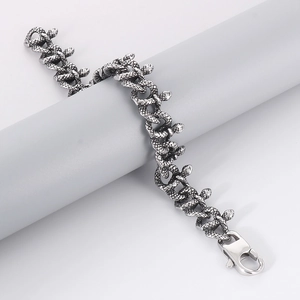 Detailed view of silver snake-patterned chain bracelet with polished lobster clasp