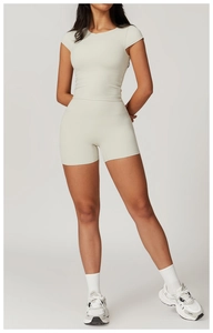 Dettaglio degli shorts da yoga a vita alta beige chiaro e del top sportivo a maniche corte