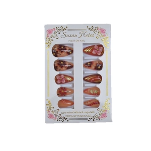 Brown almond press-on nails with floral gradients, gold foil, and pearl accents