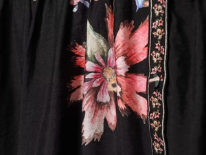 Détail macro du motif floral de qualité avec fleurs roses sur une robe noire élégante