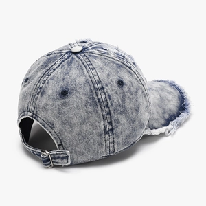 Distressed blue wash denim baseball cap with frayed edges and adjustable metal buckle back