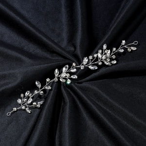 Elegant bridal hair vine with silver rhinestones and crystals on a black textured background