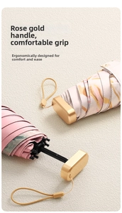Close-up of rose gold flat ergonomic umbrella handle with hanging strap and floral fabric