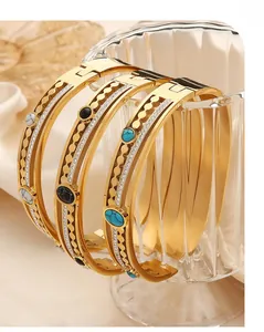 Detailed macro view of gold plated multi-layer bangles with turquoise and zircon stones