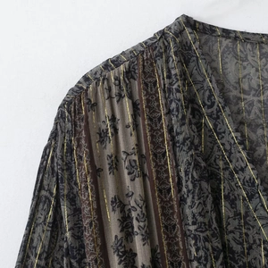 Détail d'une robe plissée en lin avec imprimé floral et rayures métallisées dorées
