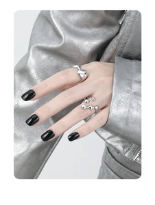 Macro shot of liquid metal style irregular silver rings on model with chrome jacket