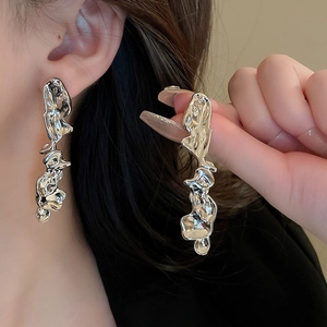 Detailed view of silver irregular fluid earrings with metallic luster on model