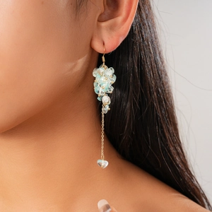 Dettaglio di orecchini vintage in oro con cluster di acquamarina e nappa a cuore