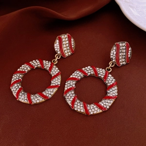 Macro detail of gold flower earrings with red enamel and pavé crystal rhinestones