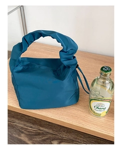 Détail du sac en nylon bleu paon avec poignée plissée et cordon de serrage latéral