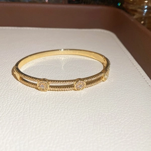 Gros plan d'un bracelet doré à double rangée avec des zircons cubiques et fermoir à charnière