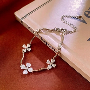 Elegant silver flower bracelet with zircon and mother of pearl on a red velvet background