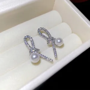 Elegant silver bow stud earrings with sparkling cubic zirconia and white round pearls