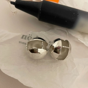 Detail shot of spherical S925 sterling silver earrings with visible metal hallmark stamp