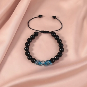 Macro detail of handmade beaded bracelet with blue galaxy beads and adjustable black cord