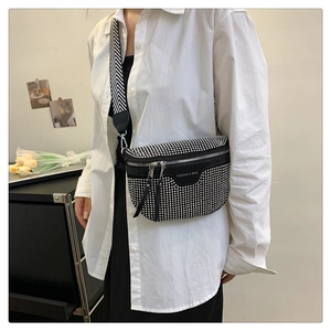 Detail of black semi-circle saddle bag with silver studs and wide chevron strap