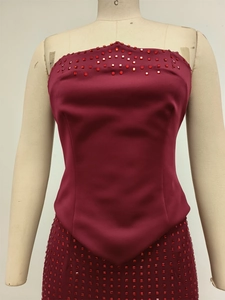 Détail d'une robe de soirée bordeaux avec broderie de perles carrées sur satin fin