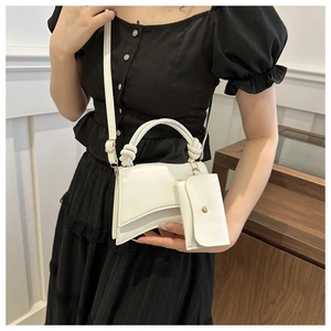 Détail d'un sac à main sablier blanc avec poignée nouée et porte-monnaie amovible