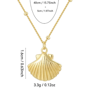 Gold shell pendant necklace with twisted chain and small gold beads on white background