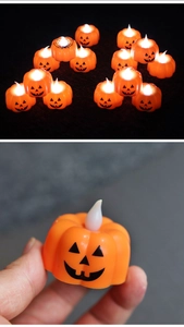Detail of hand holding a small glowing orange LED pumpkin lantern for Halloween party decor