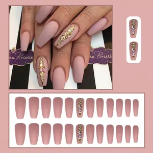 Detail view of long matte pink coffin press-on nails with rhinestones and beads