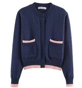 Détail du cardigan en maille bleu marine avec bords roses et fermeture à boutons