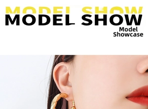 Detail shot of a model wearing high-shine golden twisted hoop earrings in vintage style