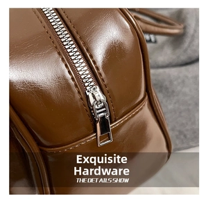 Detail of silver metal zipper and dark brown oily leather texture on shoulder bag