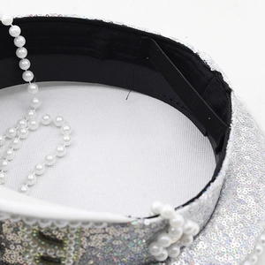 Detail of silver sequin captain hat showing interior sweatband and elastic strap