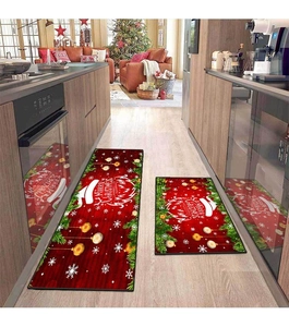 Close-up of red Merry Christmas kitchen rugs with snowflake and pine branch decorations