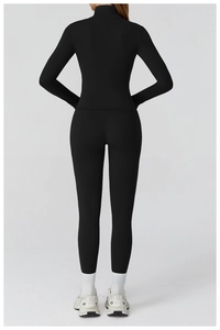 Detail view of the high-waist yoga pants and form-fitting long sleeve back in black