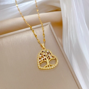 Gold tree of life heart necklace with shimmering crystals on a white silk background