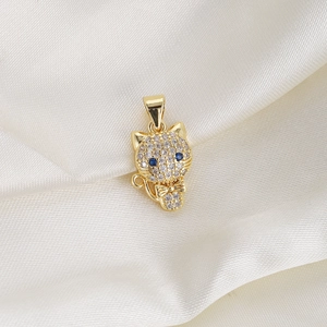 Close-up of golden cat pendant with sparkling clear crystals and blue rhinestone eyes