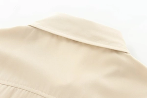 Close-up of the lapel collar and fine twill texture on this beige button-down shirt